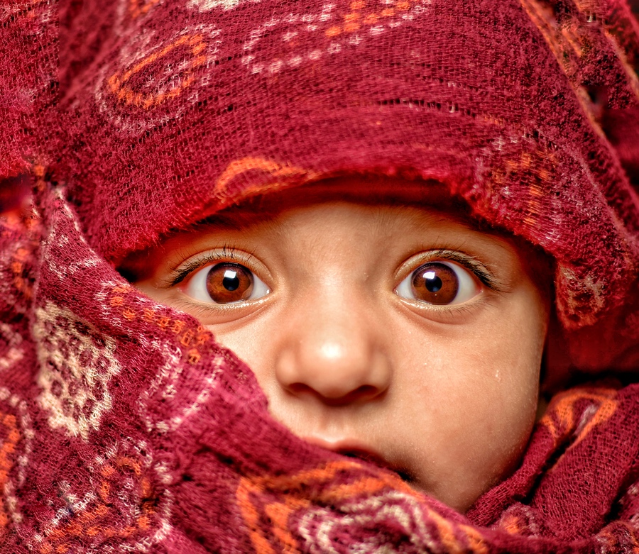 Photo by Alcon associate Ankur Sharma, showing baby looking out from wrappings of colorful fabric