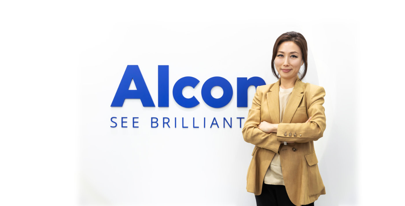 Nicole Bang standing next to Alcon sign