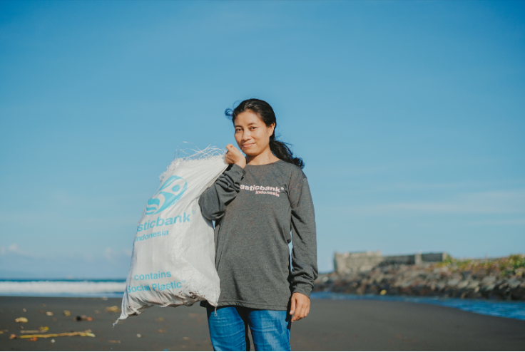 Woman with bag of plastic waste collected from beach