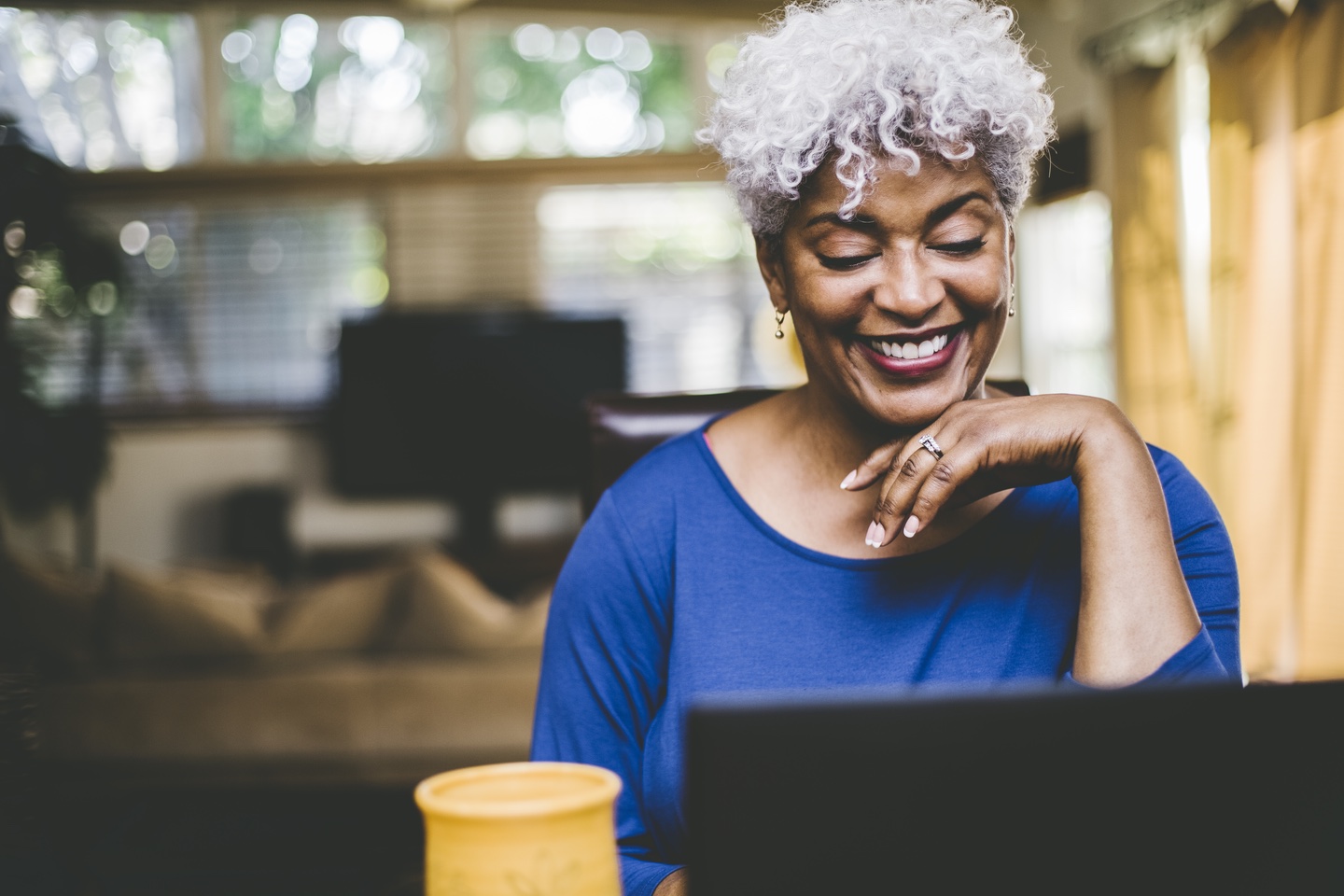 Woman smiling and working on laptop computer