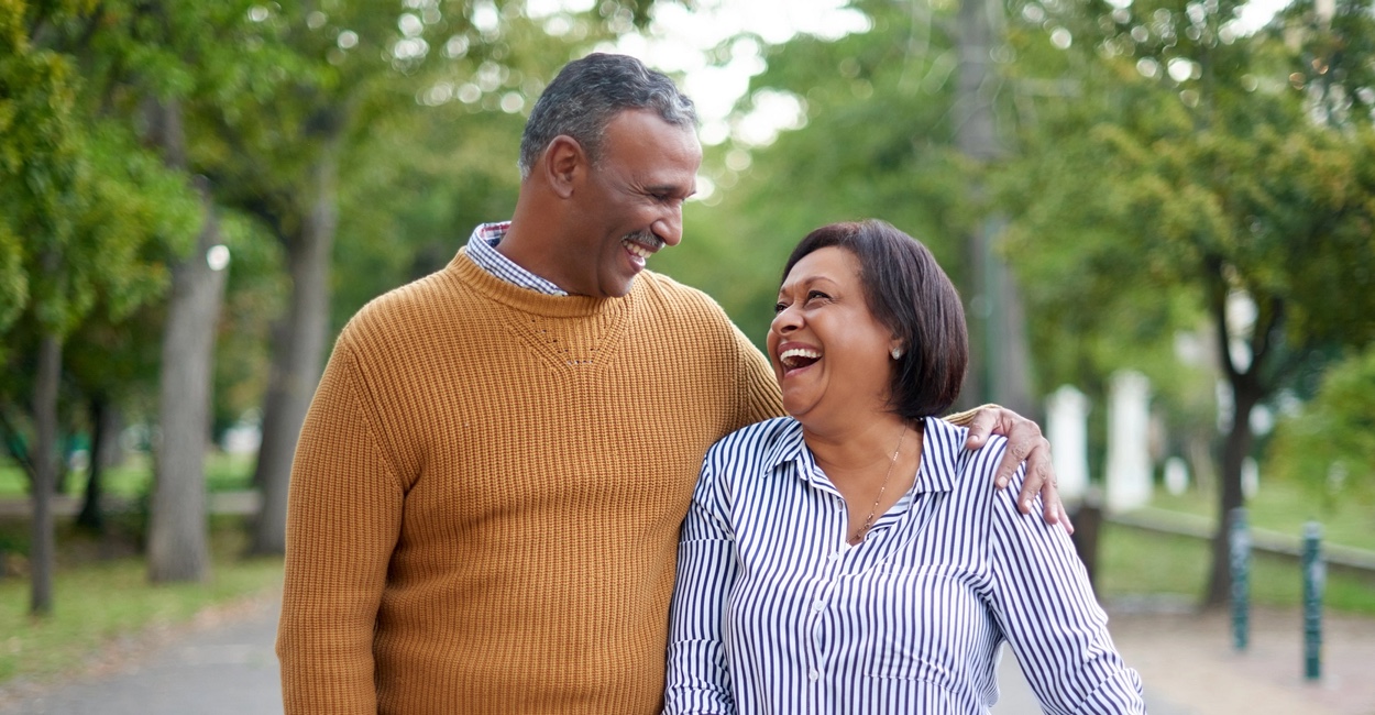 mature man and woman walking in park and smiling