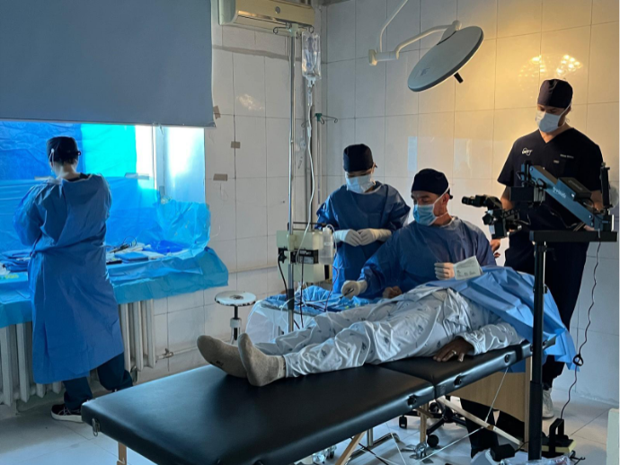 Operating room with patient on table and medical staff in surgical gear conducting procedure