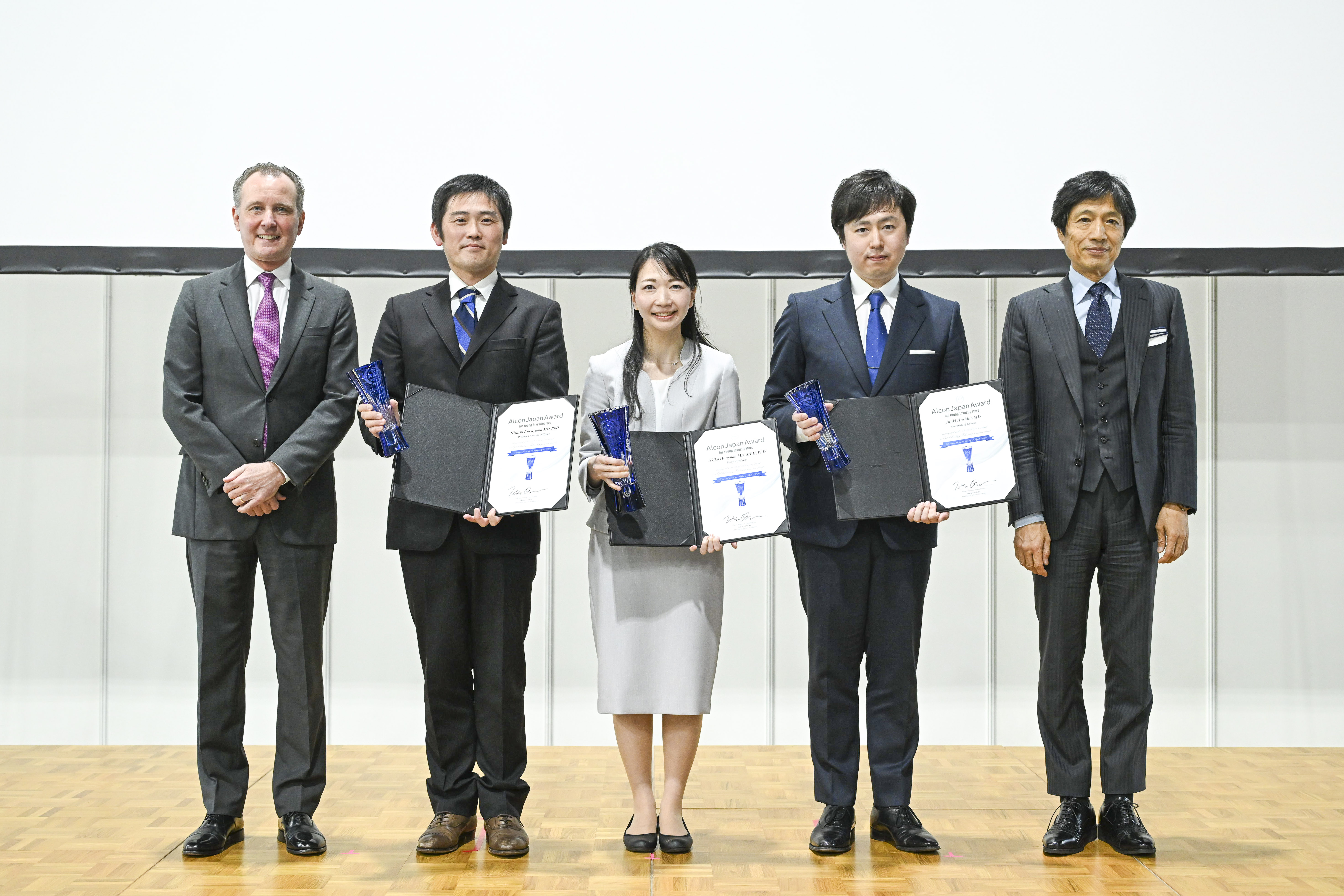 Group photo, with 3 people holding awards