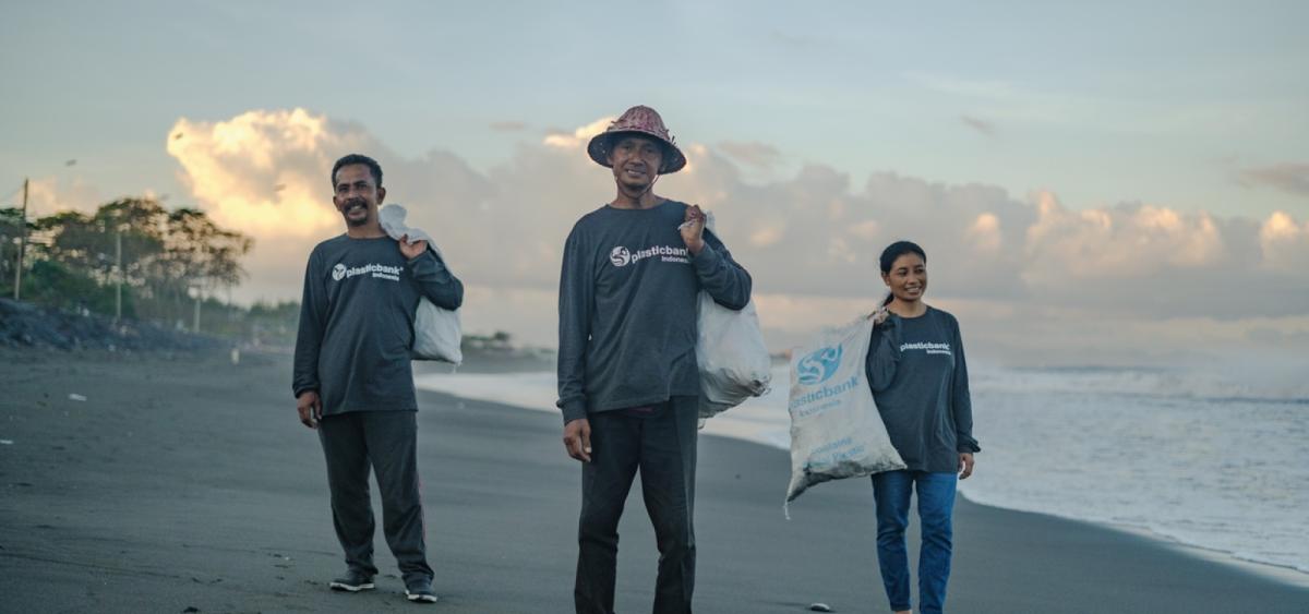 Three people in Indonesia collecting plastic along beach