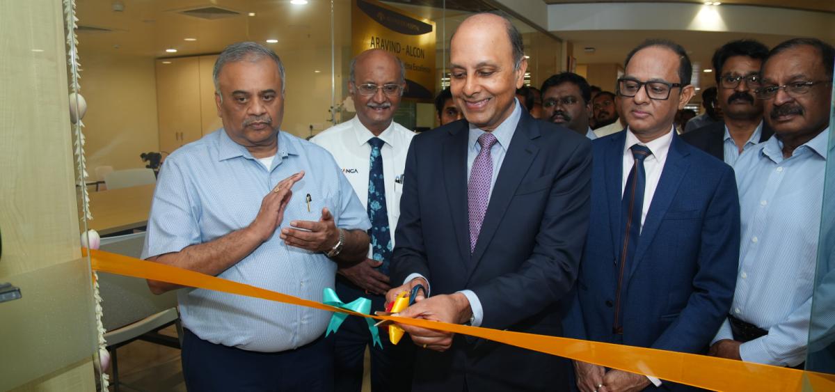 Five men in business dress smiling. One is cutting a ribbon on the new Aravind Retina Centre of Excellence