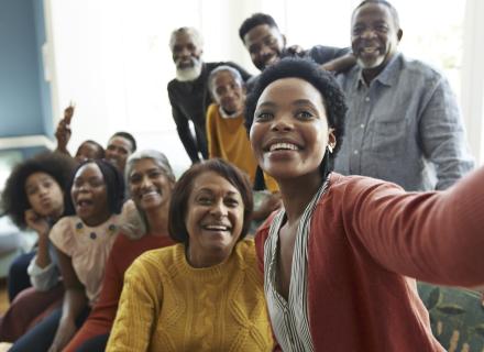 Group of people smiling and taking a selfie photo