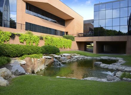 View of a stone-lined pond with green landscaping outside the Fort Worth, Texas office