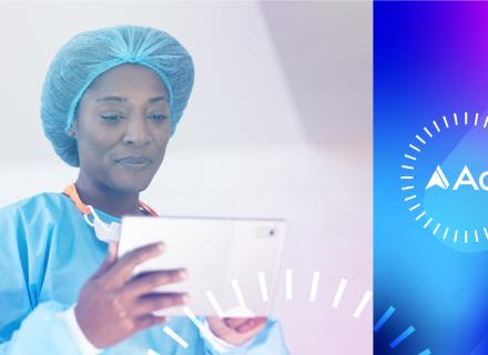 Woman in surgical gown and cap looking at ipad, Adi logo on right