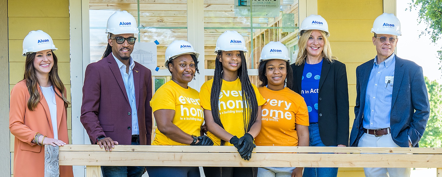 Alcon employees posing in front of Habitat For Humanity home